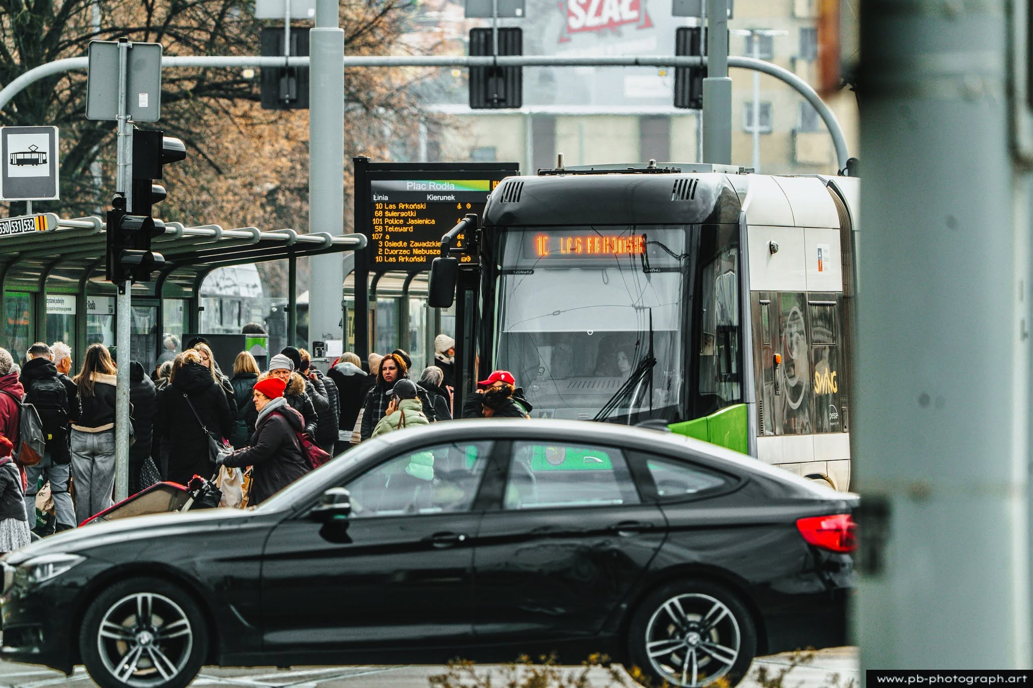 Ujęcie z życia miejskiego w Szczecinie — przystanek autobusowy z pasażerami i nadjeżdżającym autobusem.