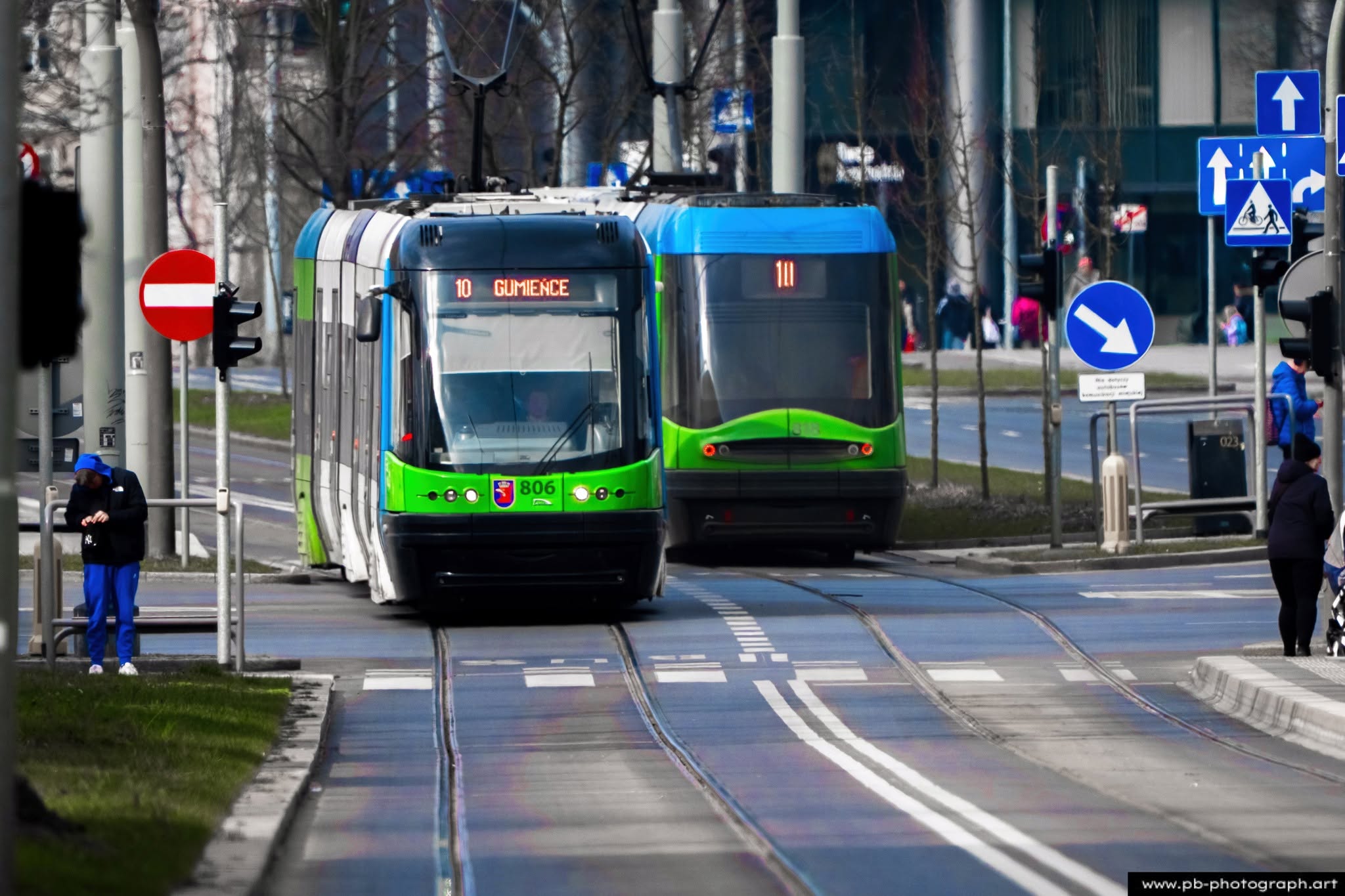 Tramwaje w Szczecinie na ulicy, jedno z nich z numerem 10, w ruchu na tle miejskiego krajobrazu.