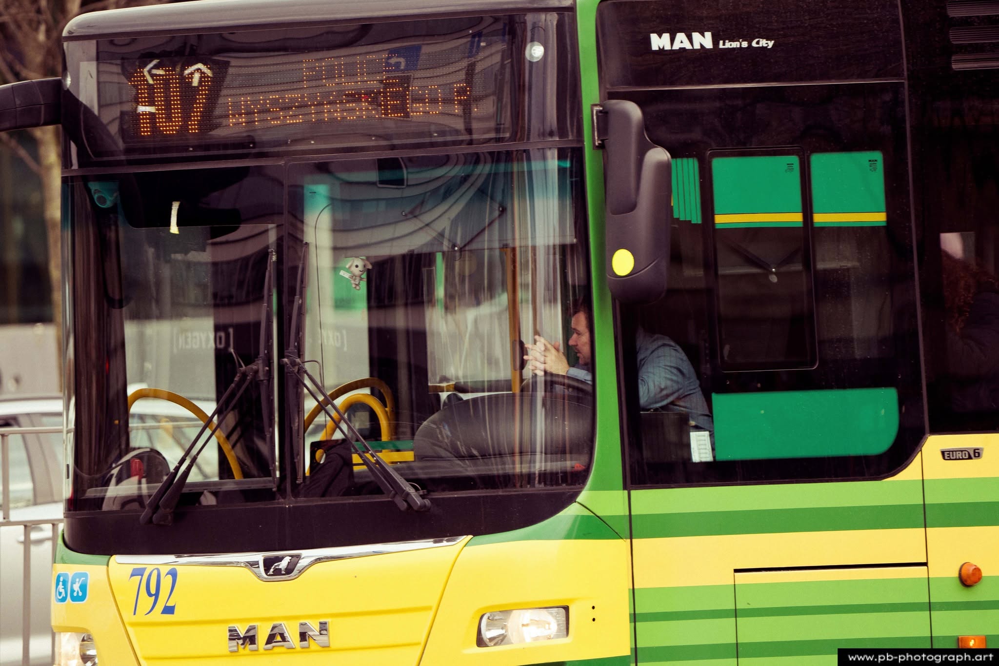 Fotografia uliczna w Szczecinie — kierowca autobusu miejskiego w kabinie podczas przystanku.