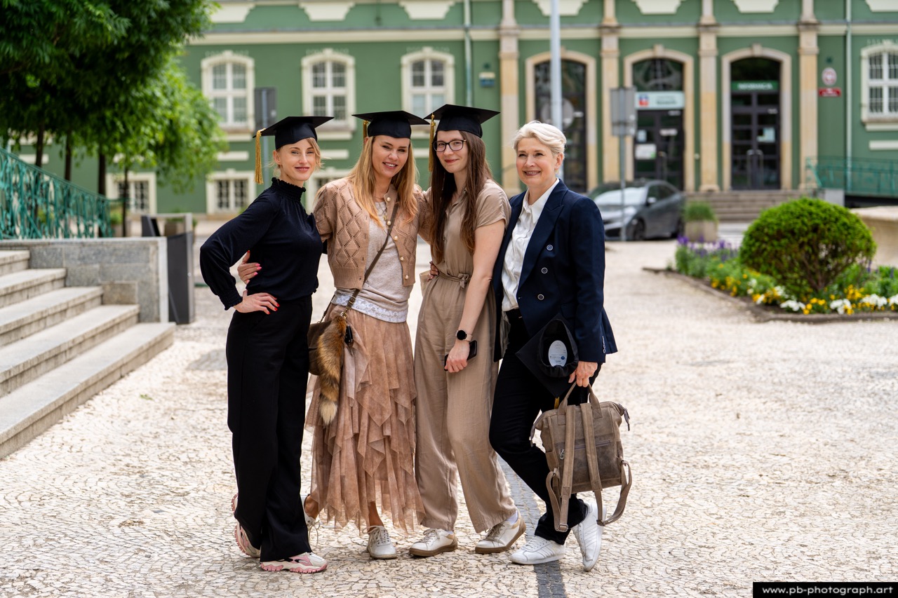 Reportaż z absolutorium w Szczecinie — grupa absolwentek w togach na tle Urzędu Miasta.