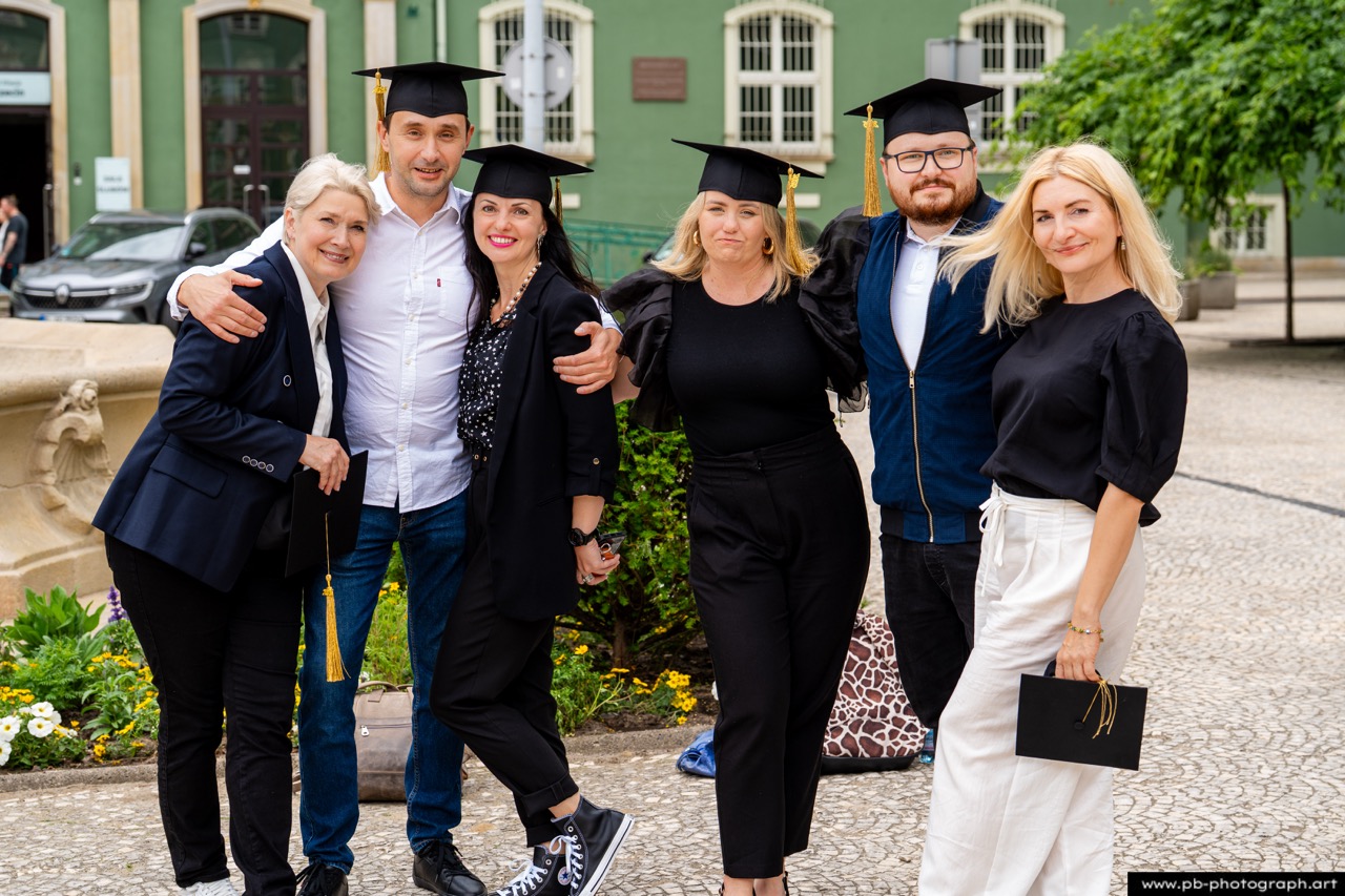 Reportaż z absolutorium w Szczecinie — grupa absolwentów z dyplomami w Parku Kasprowicza.