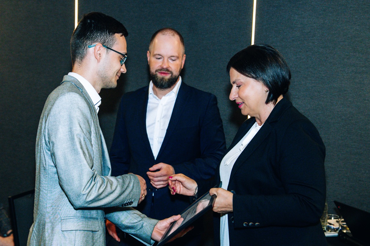 Wręczenie certyfikatów w piwnicy hotelu Fokus, emocje uczestników na tle ciemnych ścian.