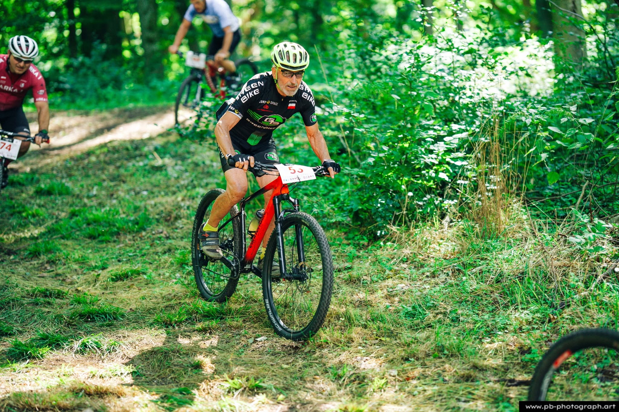 Fotografia sportowa z wyścigów MTB w Szczecinie — zawodnik na trasie wśród zieleni.
