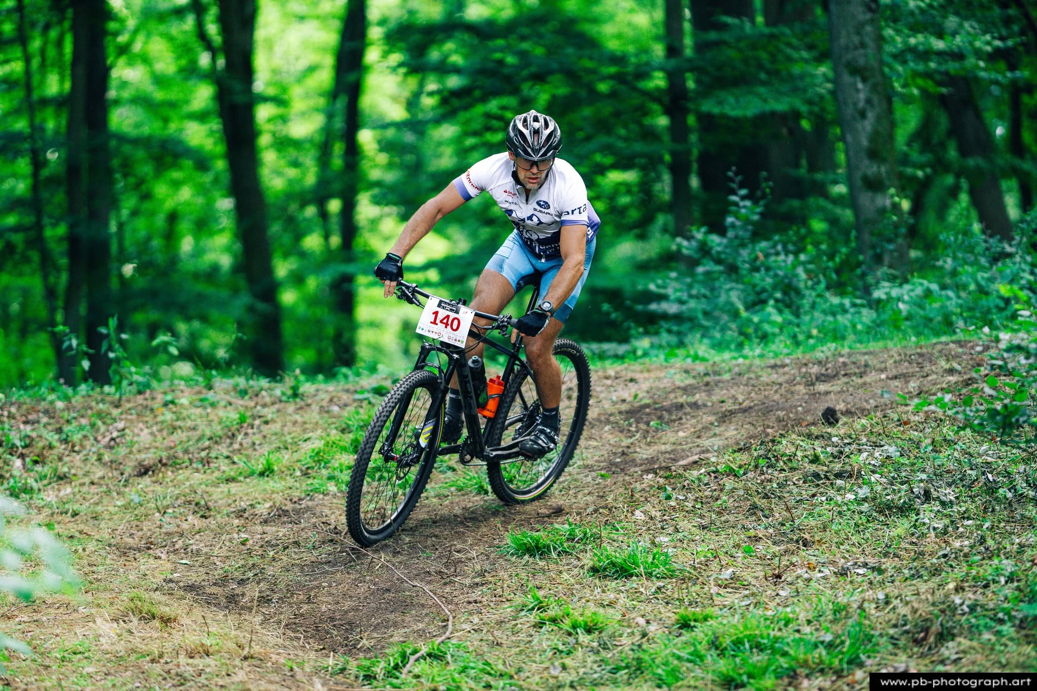 Fotografia sportowa z wyścigów MTB w Szczecinie — zawodnik na trasie w lesie.