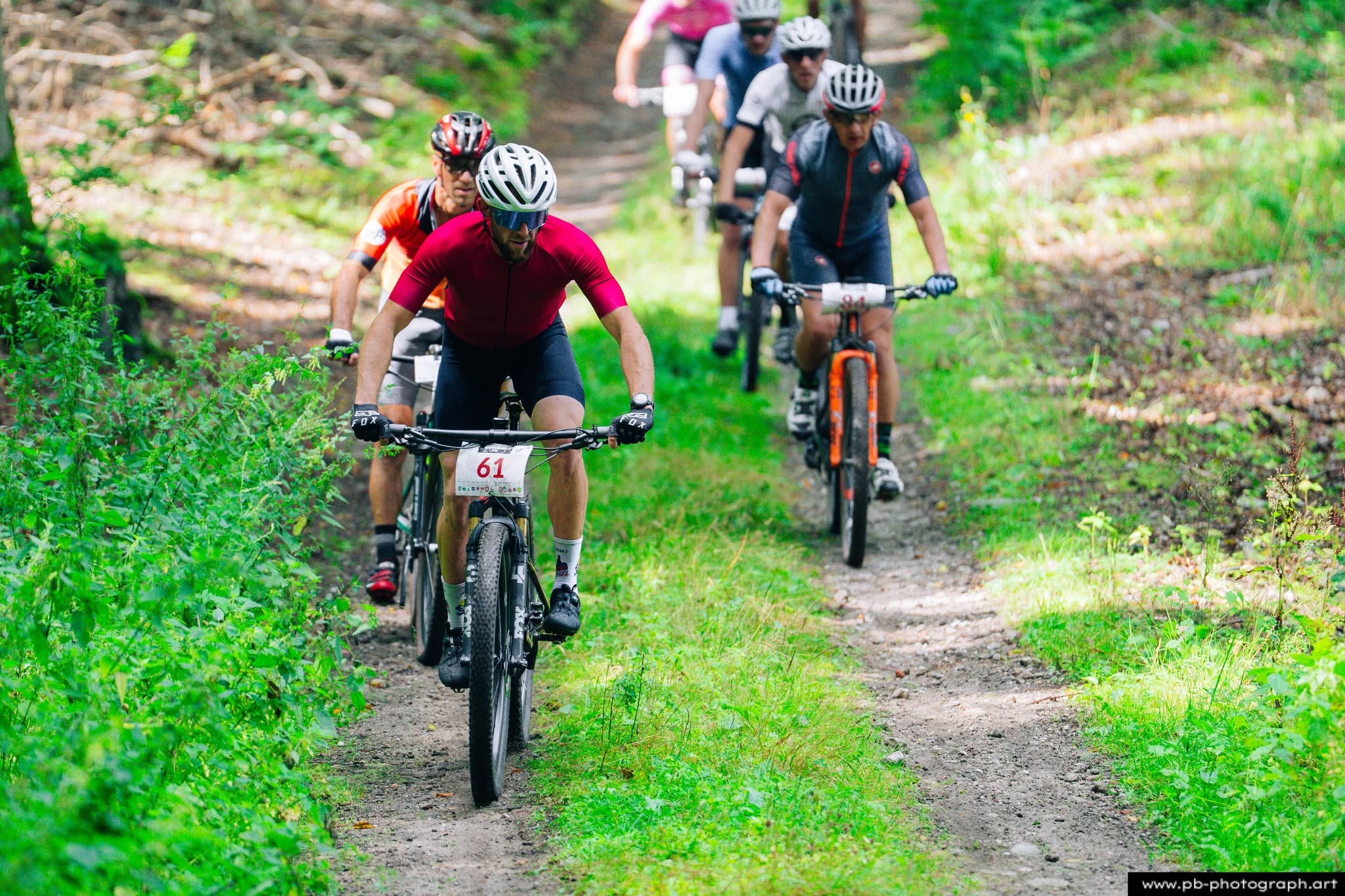 Fotografia sportowa z wyścigów MTB w Szczecinie — zawodnicy na trasie w lesie.