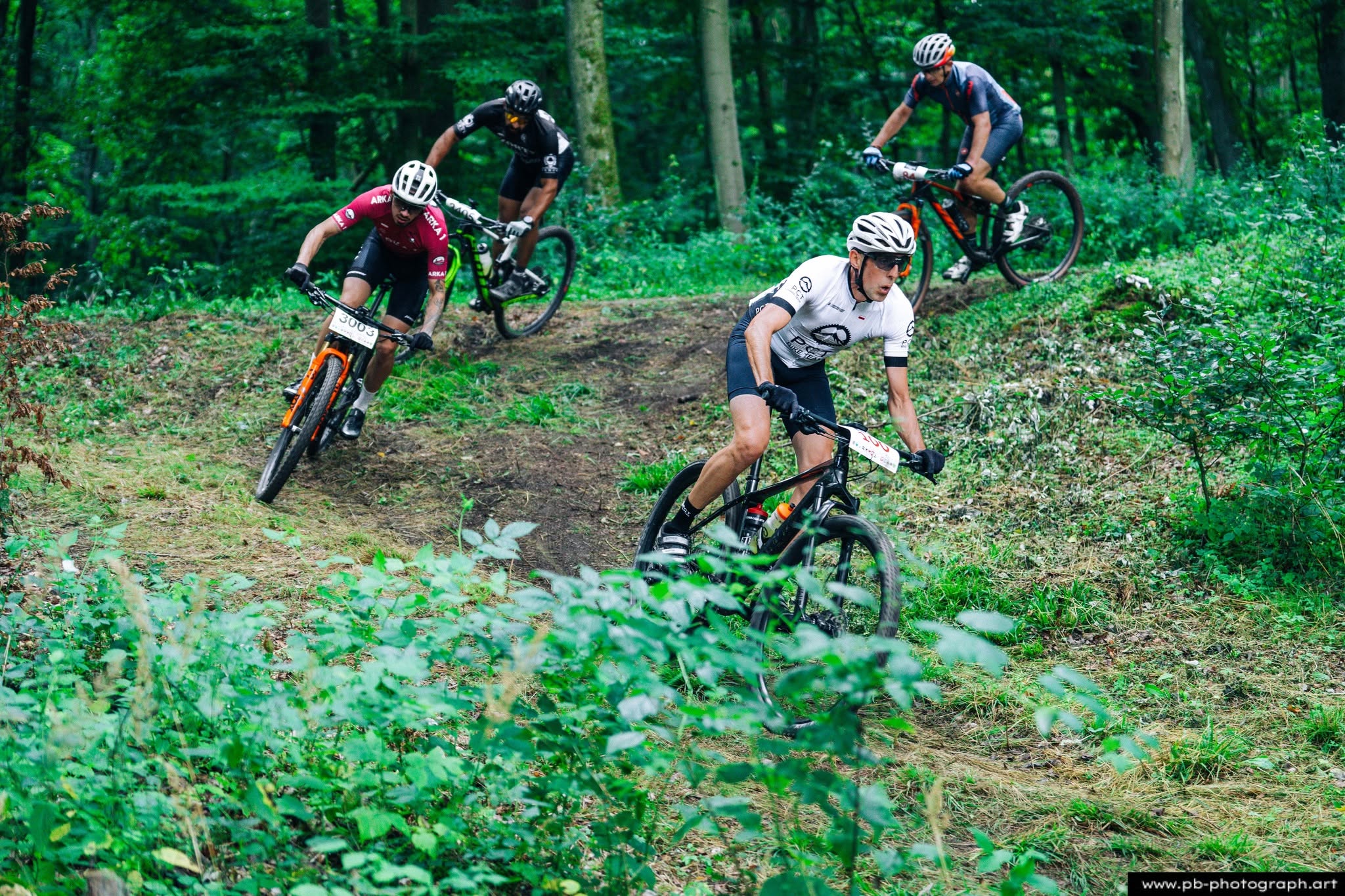 Fotografia sportowa z wyścigów MTB w Szczecinie — rowerzyści na trasie w lesie.