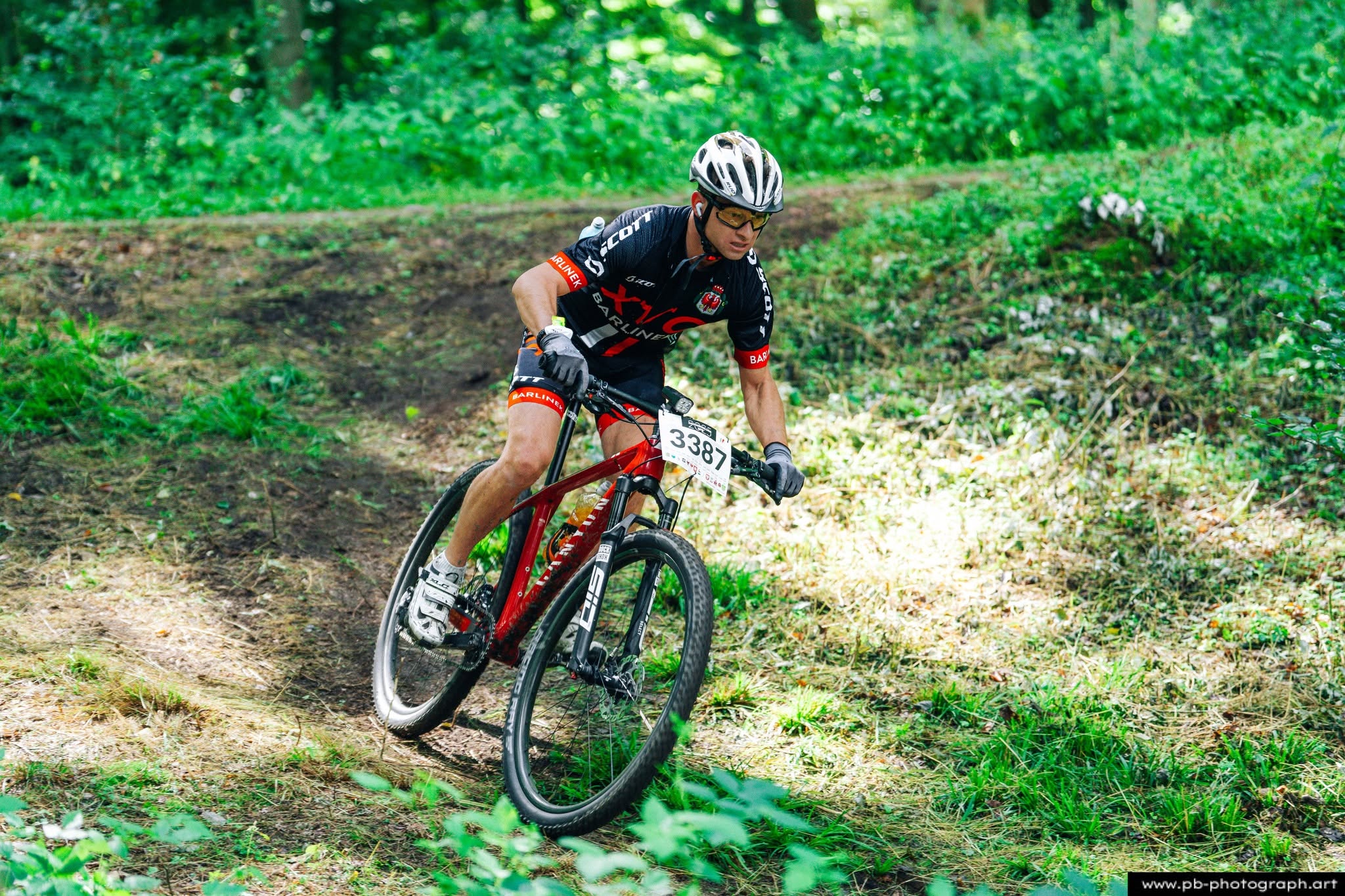 Fotografia sportowa z wyścigów MTB w Szczecinie — zawodnik na trasie w lesie.