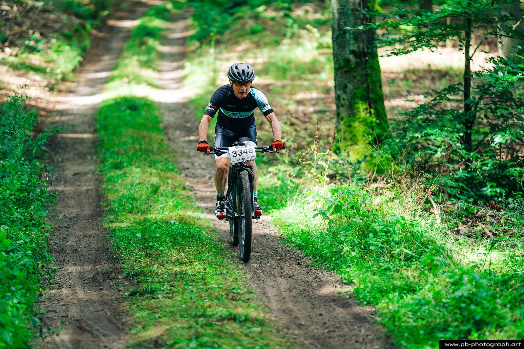 Fotografia sportowa z wyścigów MTB w Szczecinie — zawodnik na trasie w lesie.