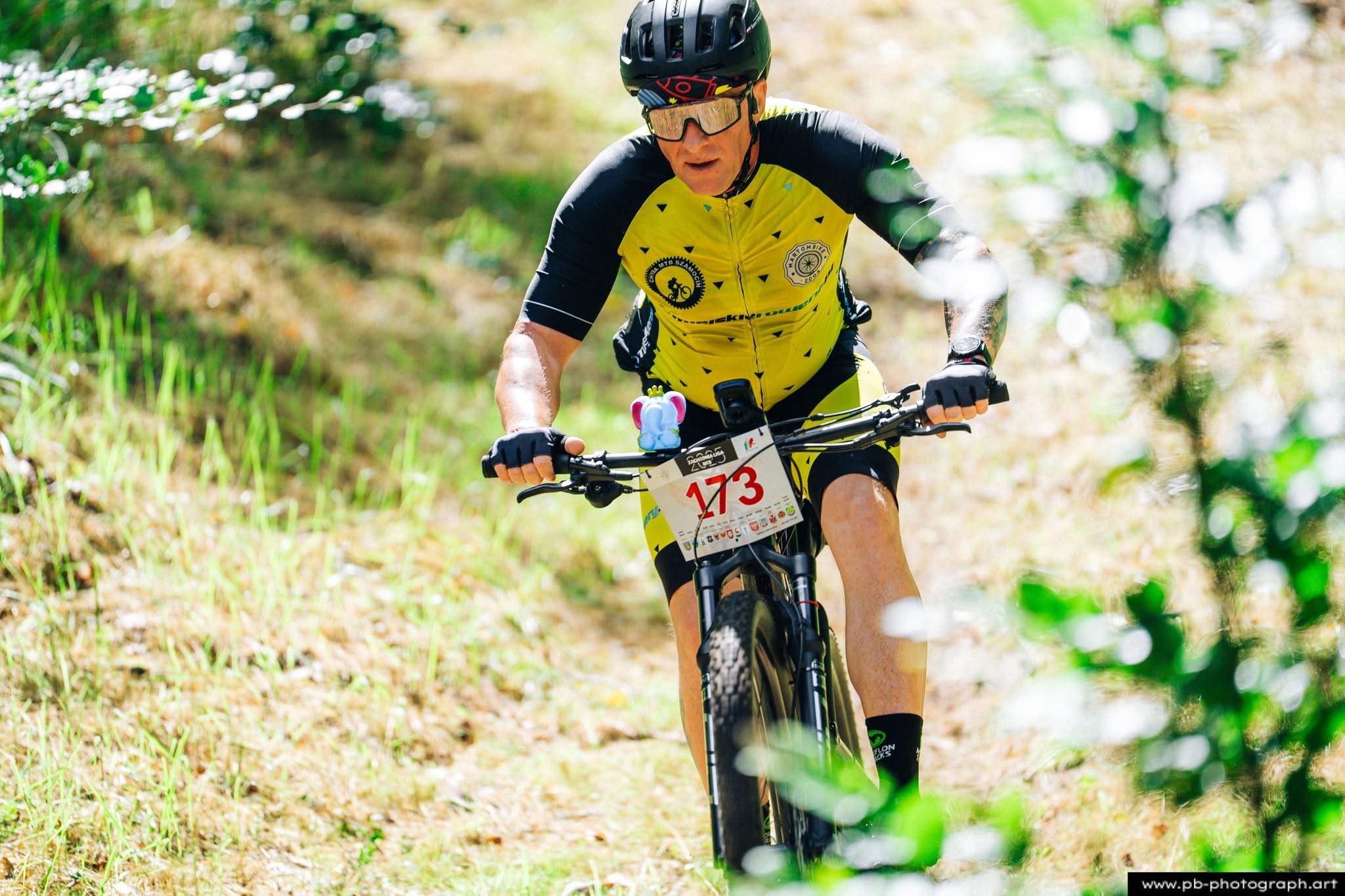Fotografia sportowa z wyścigów MTB w Szczecinie — kolarz pokonujący trasę w lesie.