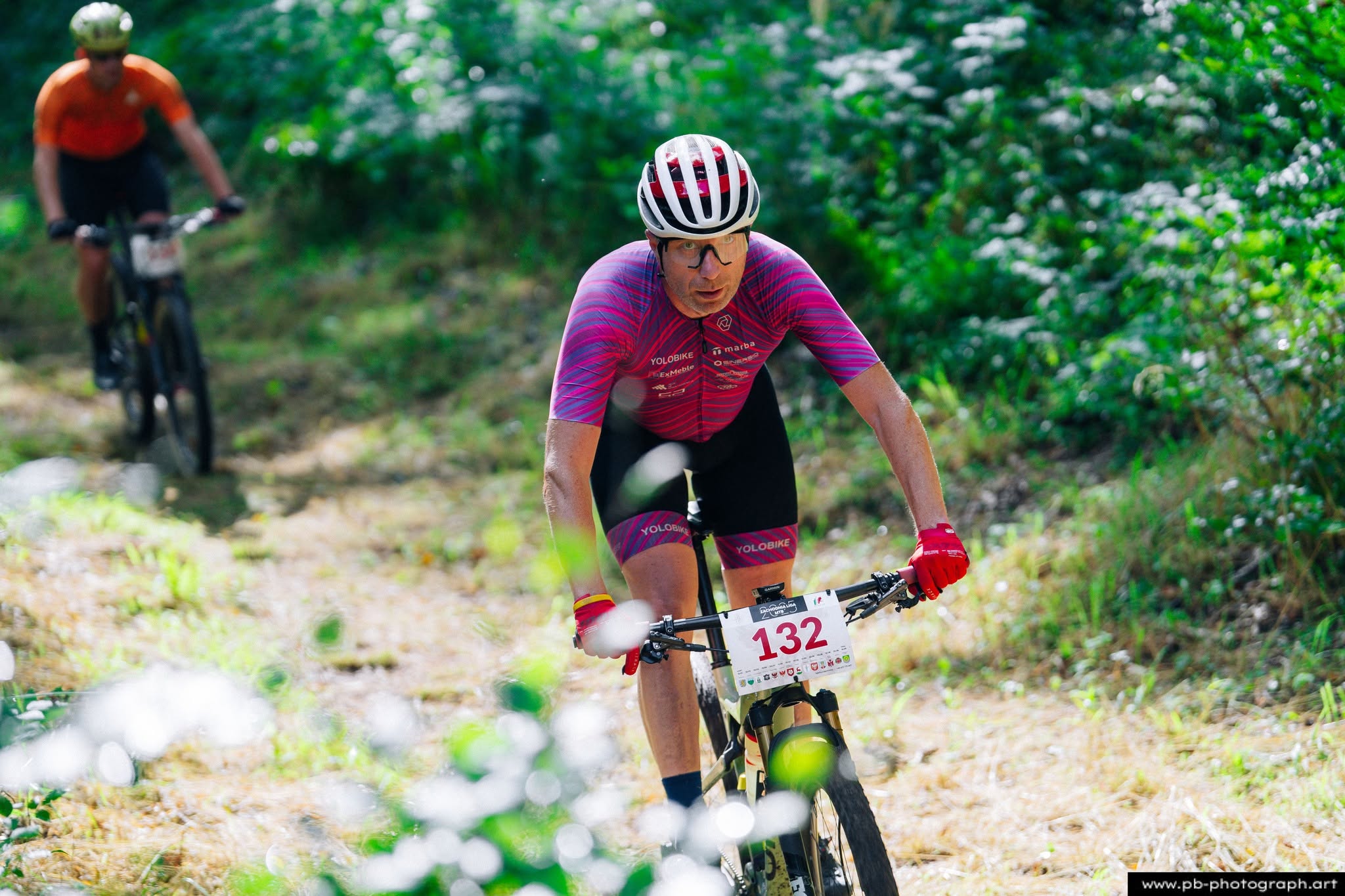 Fotografia sportowa z wyścigów MTB w Szczecinie — zawodnik na trasie wśród zieleni.
