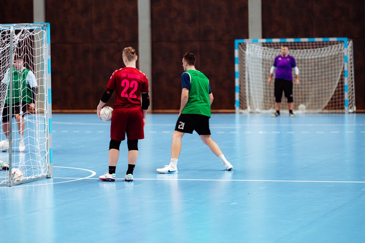 Trening Szczecińskiej Akademii Futsalu — zawodnicy w akcji na hali SDS, z bramkarzem w tle.