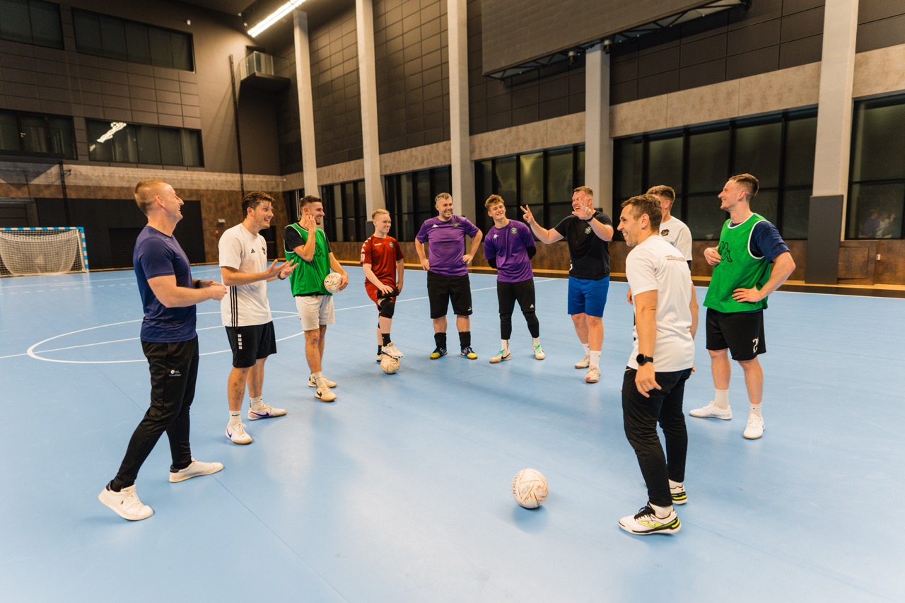 Fotografia wizerunkowa trenera mentalnego z zawodnikami Szczecińskiej Akademii Futsalu podczas treningu w Hali SDS w Szczecinie.