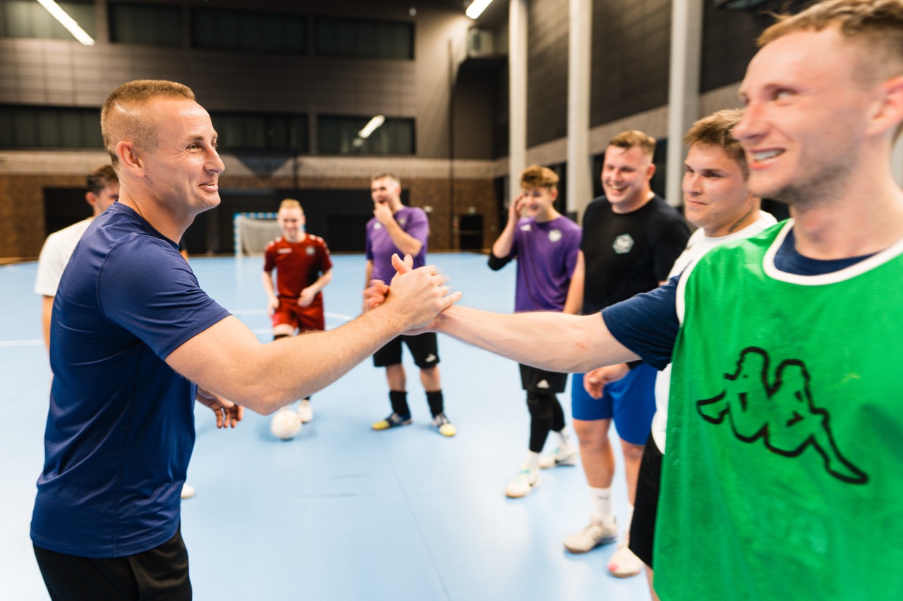 Trener mentalny w Hali SDS w Szczecinie wita się z zawodnikiem podczas treningu Szczecińskiej Akademii Futsalu.