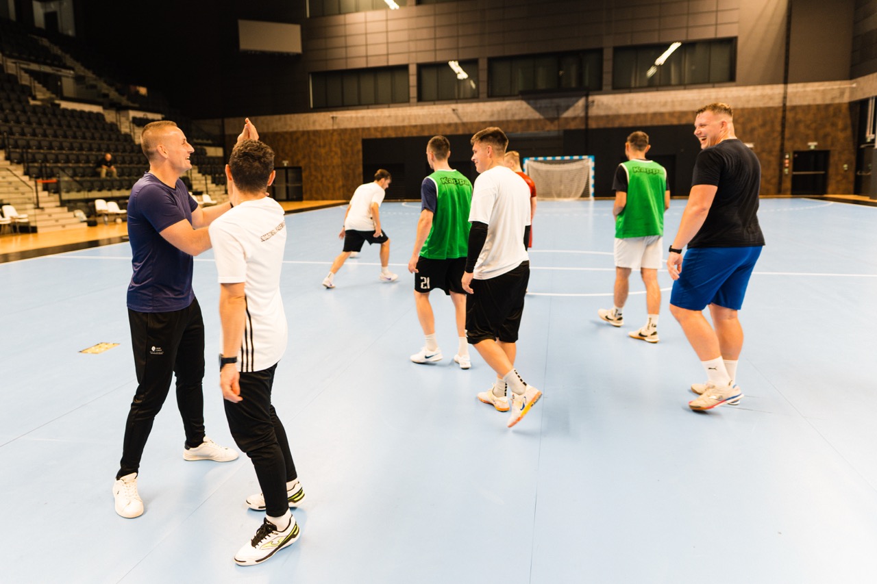 Trener mentalny prowadzi trening grupowy w Hali SDS w Szczecinie, zawodnicy w dynamicznych pozach.