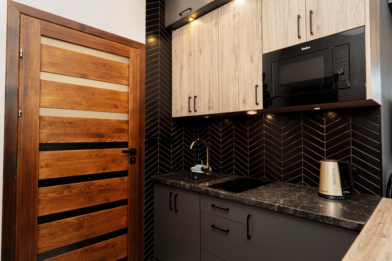 Stylowa kuchnia apartamentu w Zakopanem z nowoczesnymi meblami i eleganckimi akcesoriami.