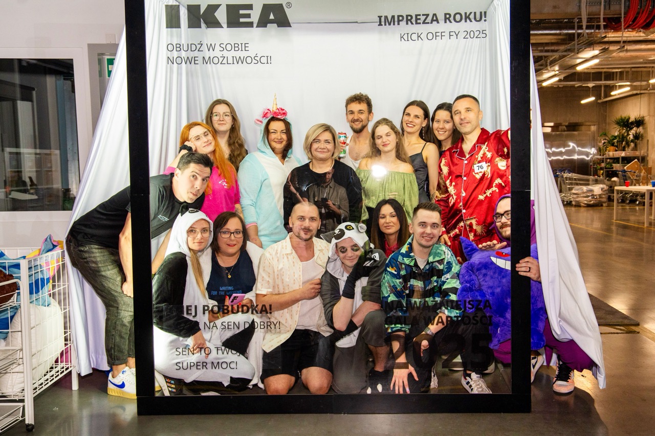Fotografia korporacyjna z wydarzenia dla IKEA w Szczecinie — grupa pracowników pozująca w kreatywnej ramie z hasłami.