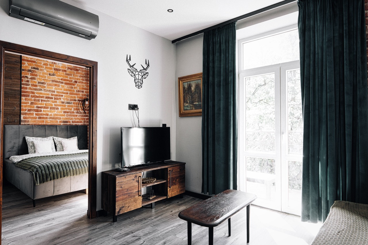 Fotografia wnętrz apartamentu w Zakopanem — stylowe połączenie cegły i nowoczesnych elementów w salonie.
