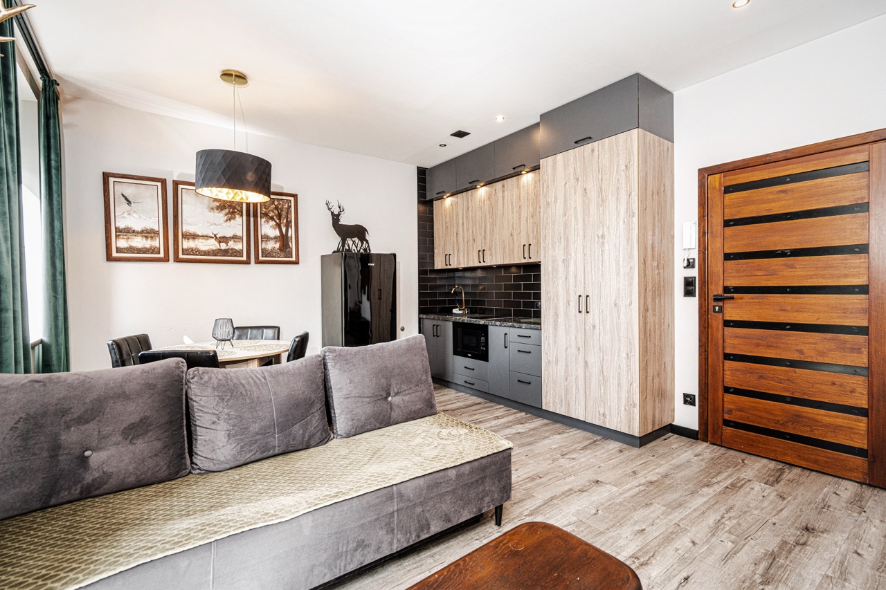 Stylowe wnętrze apartamentu w Zakopanem z nowoczesną kuchnią i przytulnym salonem.