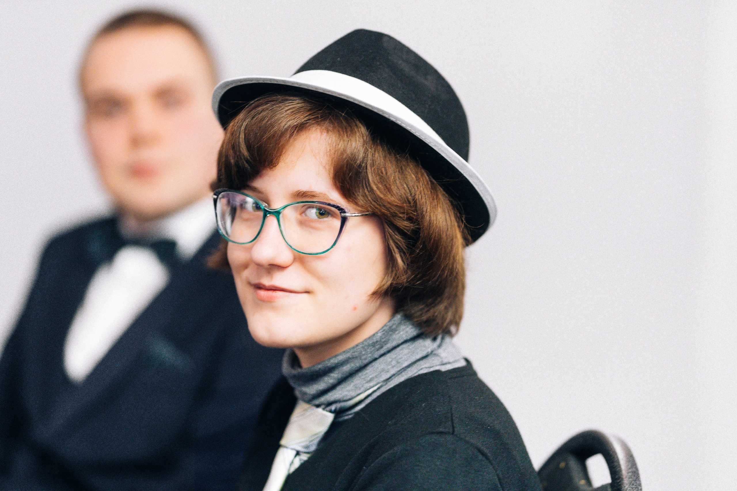 Portret dziewczyny w kapeluszu na studniówce w Hotelu Dana w Szczecinie, z uśmiechem i przytłumionym tłem.