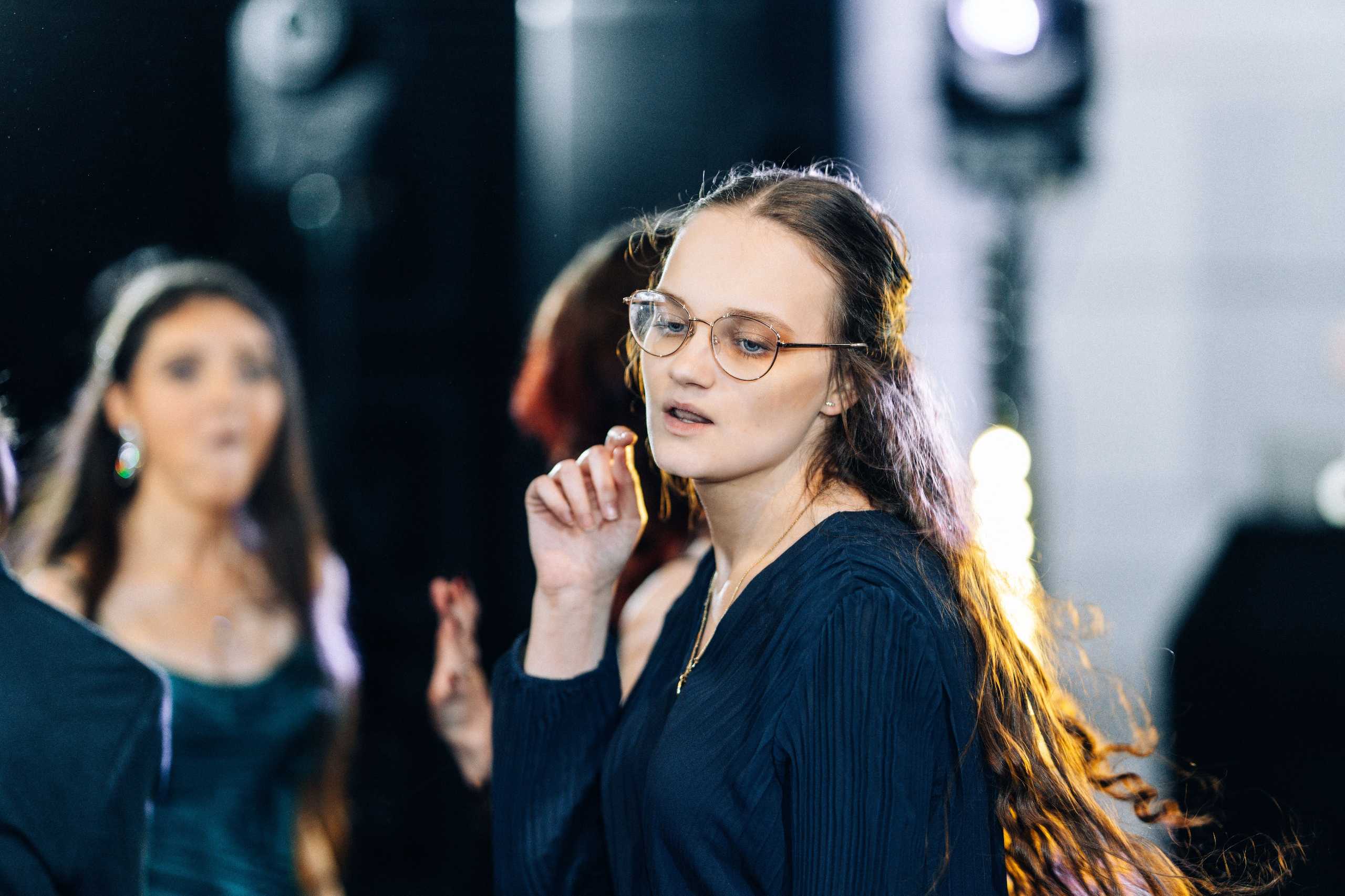 Ujęcie młodej dziewczyny tańczącej na studniówce w Hotelu Dana w Szczecinie, z wyraźnym tłem rozmytym.