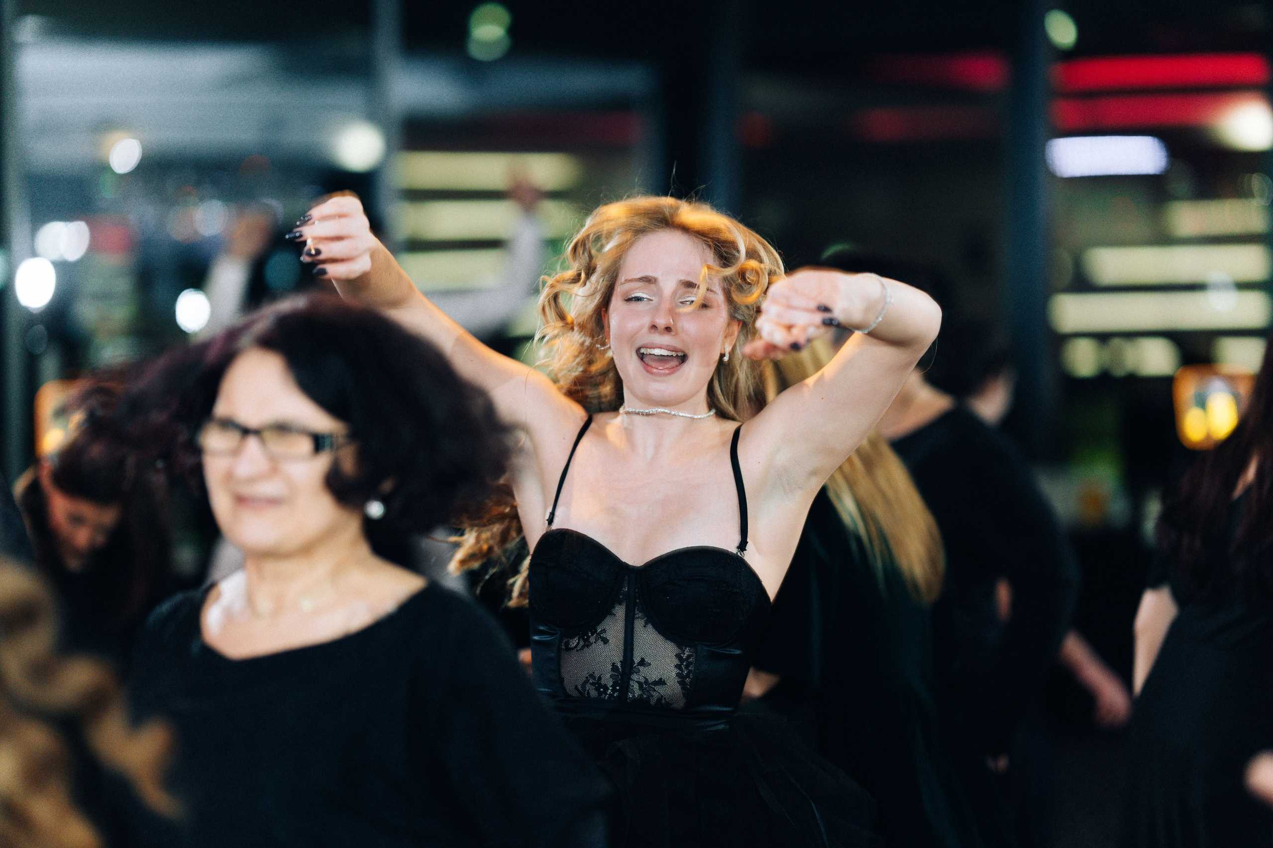 Fotografia studniówkowa w Szczecinie — młoda kobieta tańcząca z radością na parkiecie w Hotelu Dana.