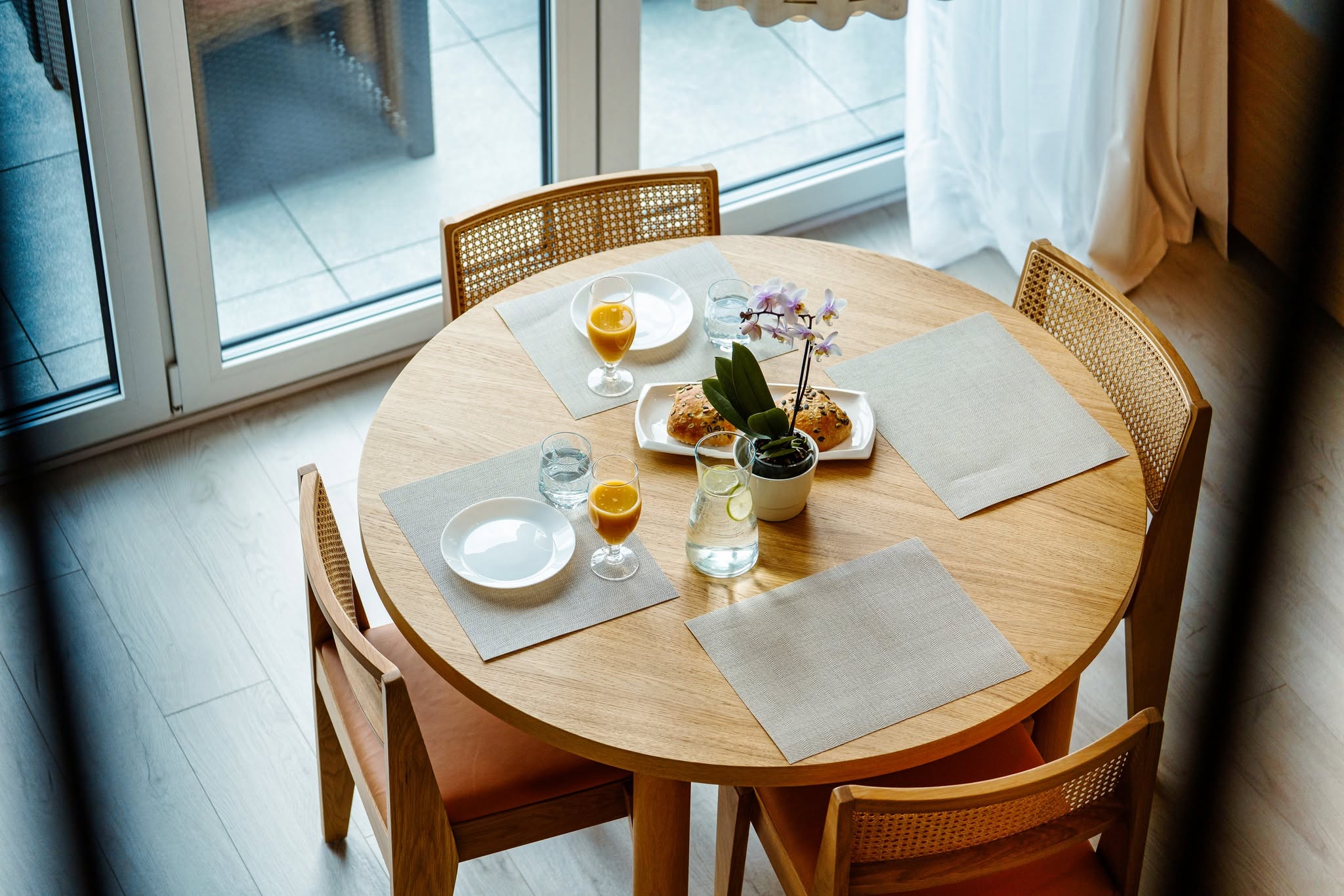 Fotografia wnętrz apartamentu w Niechorzu — stół z napojami i przekąskami w jasnym, przestronnym wnętrzu.