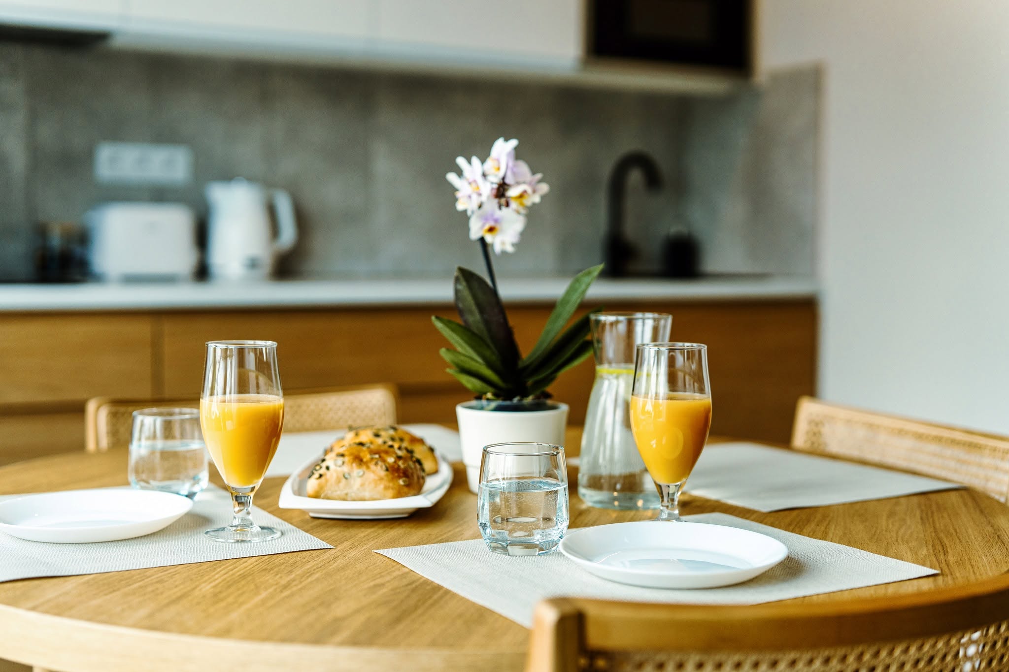 Fotografia wnętrz apartamentu w Niechorzu — stół z napojami i przekąskami w nowoczesnej kuchni.