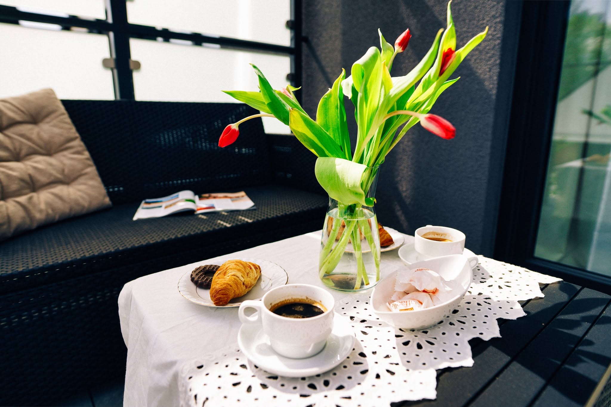 Fotografia wnętrza apartamentu w Niechorzu — stół z kawą i kwiatami na tarasie.